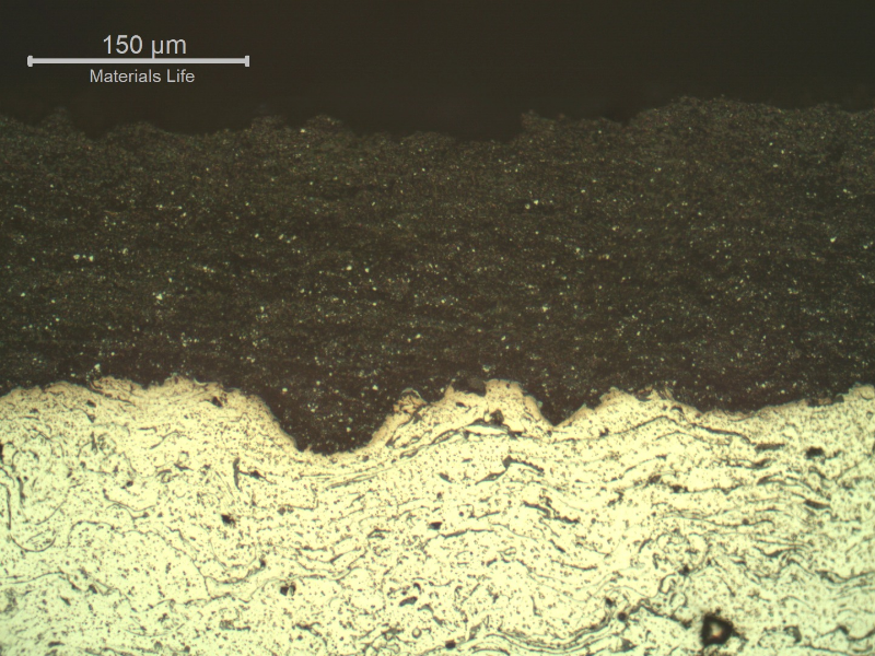 Micrography of a longitudinal section of the sleeve close to the external surface, evidencing a tugnsten carbide thermal spray layer, thickness about 0.2 mm, at the sleeve outer diameter (OD),  black due to the etch (top of the figure). This WC layer was deposited over a stainless steel layer disposed in several layers, non etched.