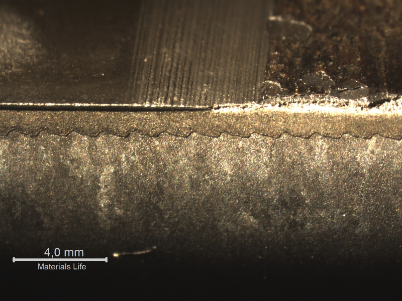 Macroscopic aspect of the OD surface of the sleeve (top of the figure), and a macrography of a longitudinal section (bottom of the figure). In the right side of the figure it is possible to see that the lack of sealing is associated to the detachment of the thermal spray surface layer.