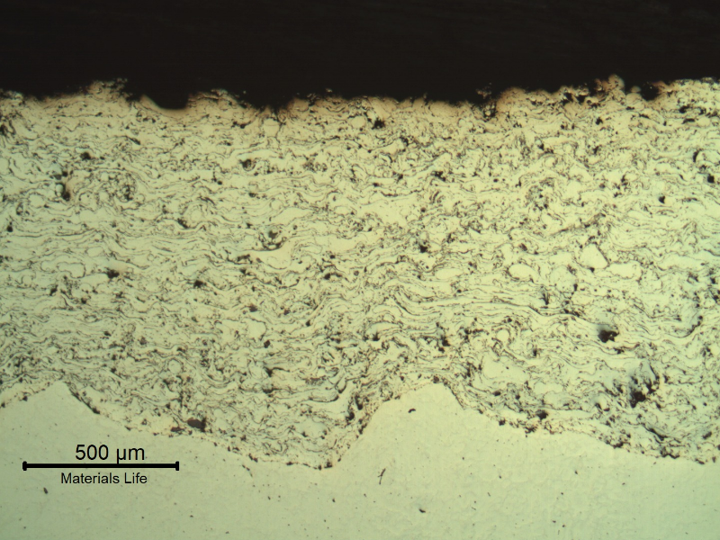 Micrography of a longitudinal section of the sleeve, in a region where the surface layer was completely removed. In this position only the stainless steel layer is at the surface. That is why the sealing condition was lost. The substrate is white in the bottom of the figure.