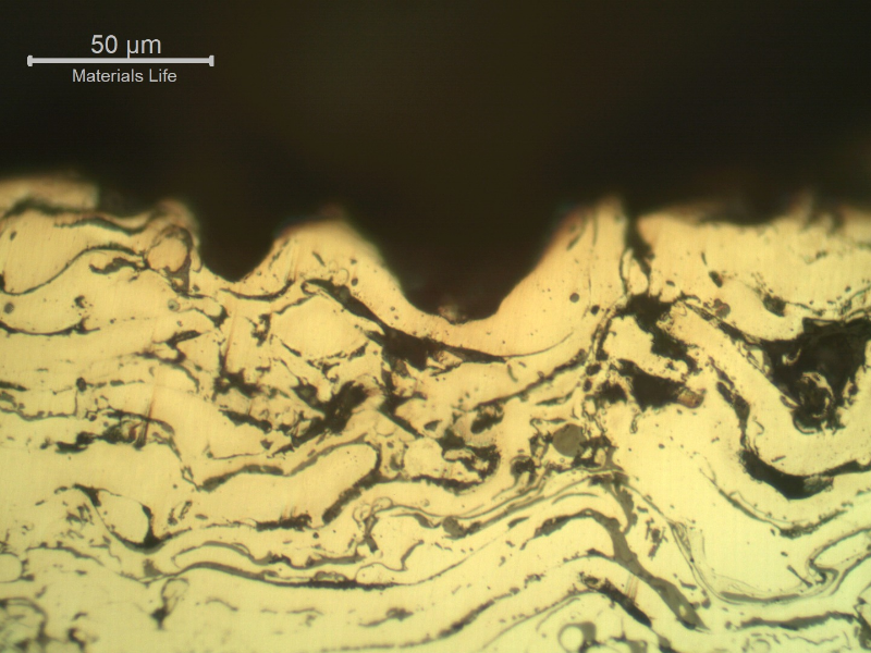 Micrographic detail of the sleeve in a region where the surface layer was completely removed.  In this position only the stainless steel layer, that is porous and full of oxides, is at the surface.