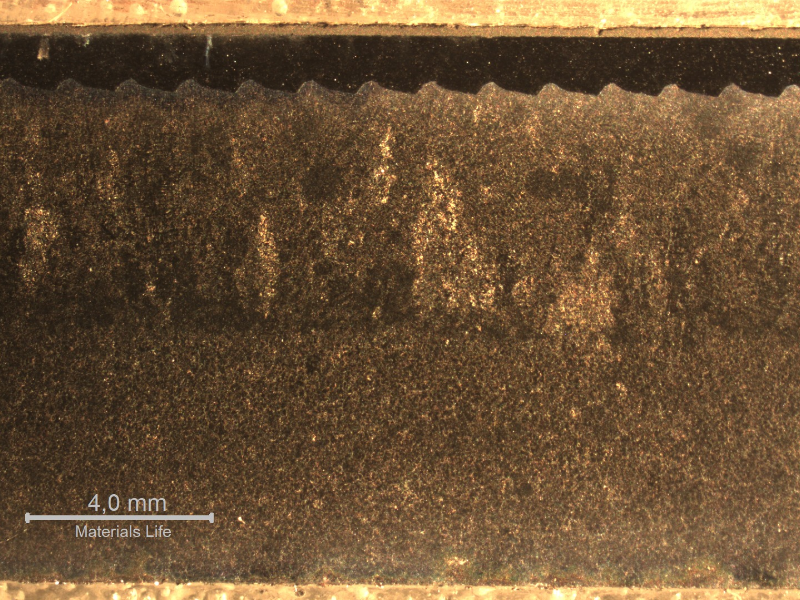 Macrographic aspect of the sleeve longitudinal section where the coating was applied in the external side (top of the figure). It is possible to see that the sleeve was manufactured by centrifugal casting, with  elongated grains from the external side, and equiaxial grains close to the internal side (bottom of the figure). There is a weaved interface between the sleeve and the first layer of thermal spray coating, 1 mm thick; and a second layer of thermal spray coating, 0.2mm thick (almost imperceptible at this low magnification).