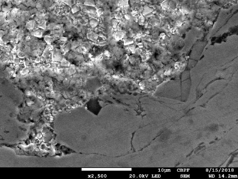 Micrographic detail by scanning electron microscopy of the interface between the two thermal spray layers, the first one in stainless steel (bottom of the figure) and the second one, at the surface,in tungsten carbide (top of the figure). The composition of the first layer is similar to the base metal (lean duplex) and the composition of the second layer is WC in a Co matrix.