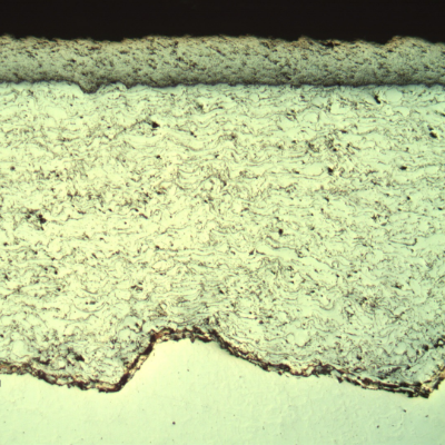 Micrography of a longitudinal section of the sleeve, in a region where the two layers applied by thermal spray are sound, not detached.  The grey layer (200 micros) is the tugnsten carbide; and the white layer (1000 microns) is a stainless steel. The substrate is  white in the bottom of the figure.