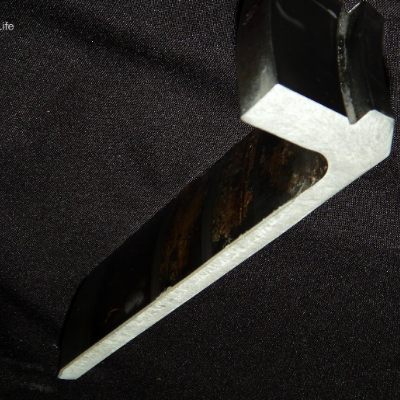 Longitudinal slice of the flanged sleeve, 180 mm long, in a macrography presenting the 1/2" tubular wall thickness where the sealing was applied.  The external surface of the sleeve (seawater wet) is in the left side of the figure and the internal surface (oiled) is in the right side. The flange is to the top of the figure.