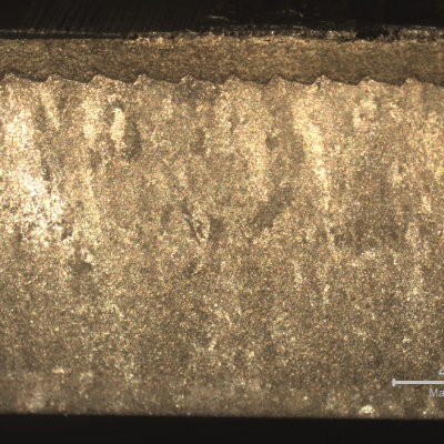 Macrography of a longitudinal section showing the region where the surface layer was detached (top of the figure), creating a lack of sealing condition.