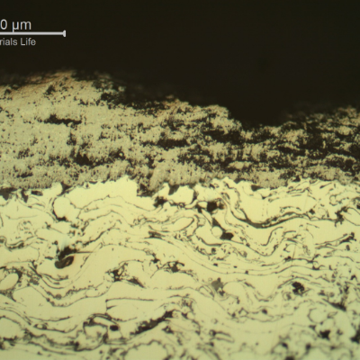 Micrographic detail of a longitudinal section of the sleeve, in a region where the WC (tungsten carbibe) surface layer was degradated and partially removed.