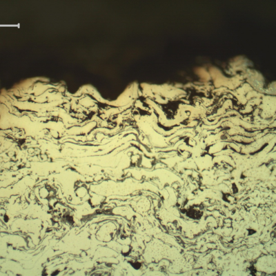 Micrography of a longitudinal section of the sleeve, in a region where the surface layer was completely removed.  In this position only the stainless steel layer, that is porous and full of oxides, is at the surface. That is why the sealing condition was lost.