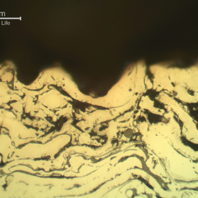 Micrographic detail of the sleeve in a region where the surface layer was completely removed.  In this position only the stainless steel layer, that is porous and full of oxides, is at the surface.