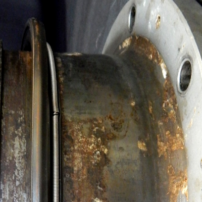 General view of the 10" diameter flanged sleeve, with the sealing rings of the seal box assembled at the sleeve external surface. The right side of the figure shows the surface region where the a lack of seal was identified, with adhered products.