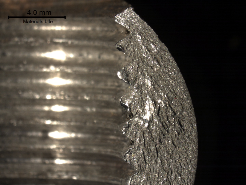 Macroscopically brittle fracture of the barrel nut, starting at the edge of the thread, as shown by the chevron marks.