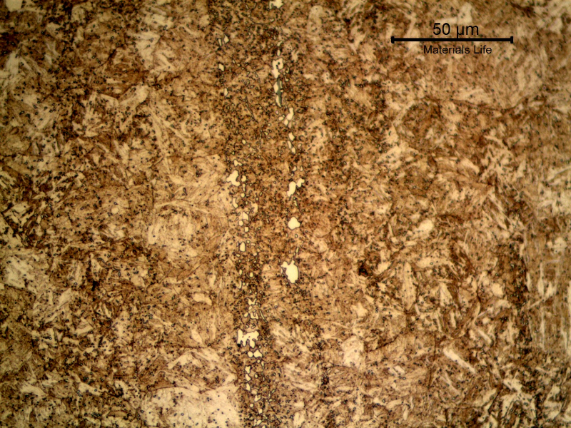Micrographic detail of the nut longitudinal section presenting the large carbides (white islands) in the segregation band, and small precipitates all through the martensite matrix, indicating that this high carbon steel was tempered in a high temperature. The 36HRc hardness also confirms this high tempering temperature.