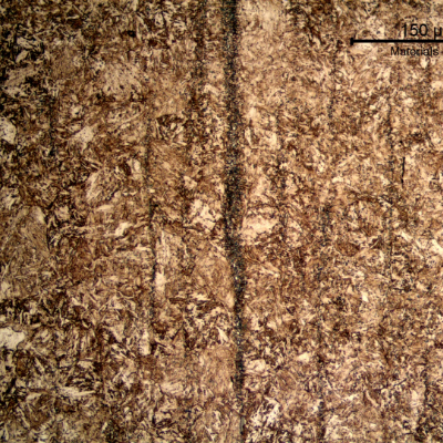 Microstructural detail of the banded structure. The rough aspect of the band is created by the carbides (better seen in the higher magnification image) in the segregation band.