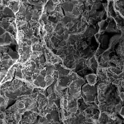 Observing in higher magnification it is possible to see that the fracture presents a mixture of ductile and brittle micromechanisms. The intergranular mechanism indicates that the material is embrittled and the dimples indicate localized overloading conditions.