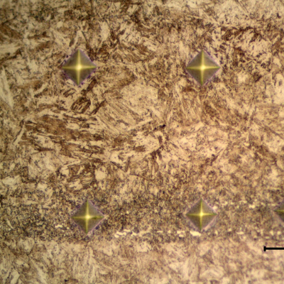 Vickers microhardness identations using 100 grams.  In a position out of the band (top line). Values from left to right, 380HV; 390HV and 394HV.  In a position inside the band (bottom line). Values from left to right, 433HV, 483HV and 473 HV.