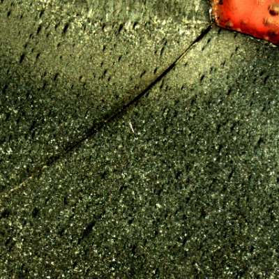 Macrography of a section tranverse to the pipe and to the weld between the 8"pipe and the 2" fitting weldolet.  The crack starts exactly at the margin of the weld, in a geometric stress concentration raiser, in a position where it growths in the pipe longitudinal direction, and propagates in a straight line, not related to any metallurgical aspect.