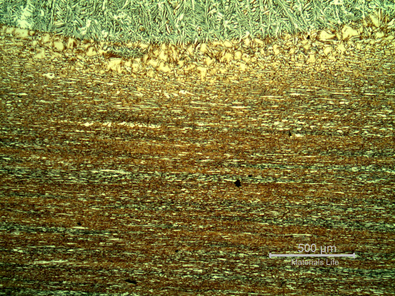 Micrography of the heat affected zone of the pipe to the fitting, at the pipe position, where the weld is in angle to the pipe (welded at the pipe surface).  Weld metal to the top.