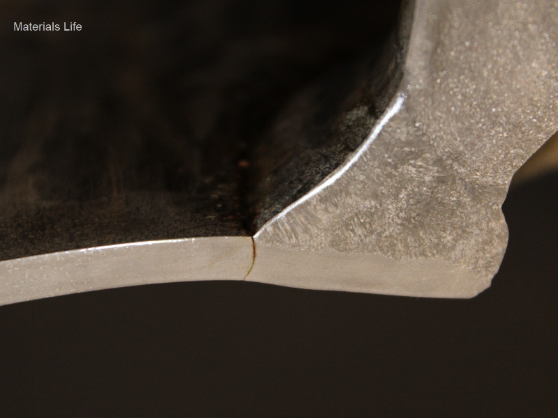 Macrographic detail of the pipe to weldolet weld, and the through wall cracking in the pipe from the margin of the weld.  The pipe thickness is only 5 mm (SCH 10S) but the large thickness of the fitting required several weld passes to create a full penetration weld.