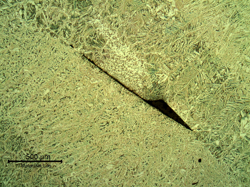 Lack of fusion between passes in the weld metal. This defect is small, probably not detectable in any destructive test and not influencing the failure.