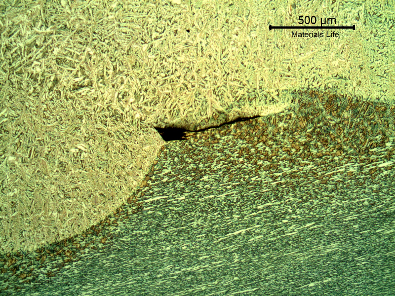 Lack of fusion at the fusion line (between the weld metal and the base metal). This defect is small, probably not detectable by any destructive test and not affecting the fatigue life.