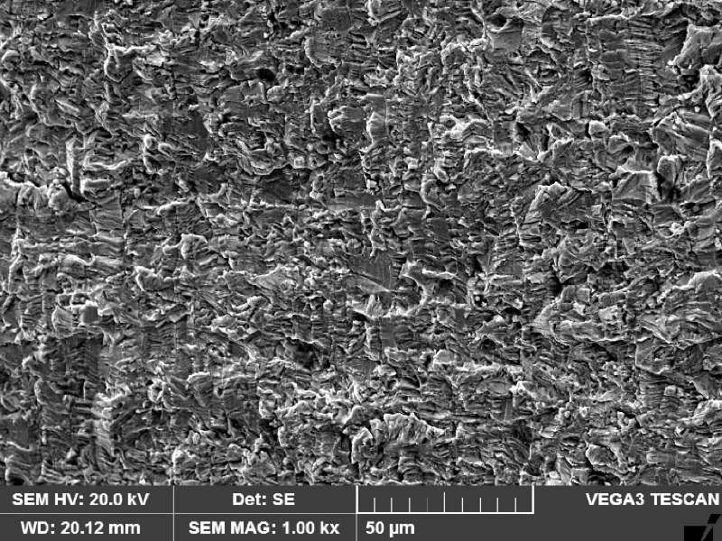 Fracture apperance by scanning electron microscopy in the center of the thickness where the crack propagated through wall. The fracture is flat and the striation is not so clear at this magnification.
