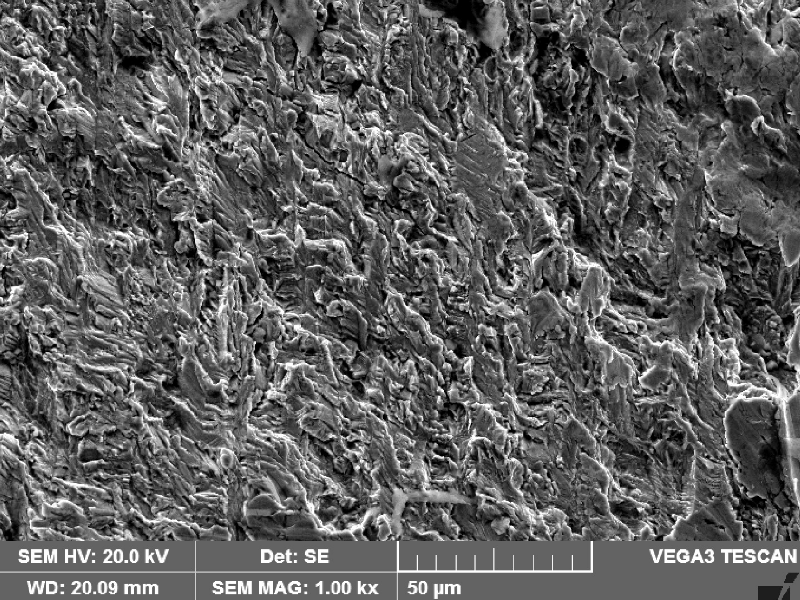 Fracture apperance by scanning electron microscopy of the region where the fatigue crack started, from the piping outside . The fracture is flat, presents some smashed regions close to the surface (to the right side) and there are some thin secondary cracks.