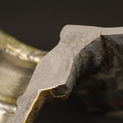 Transverse section of the 14" pipe in the center of the 2" branch using a weldolet fitting welded to the main pipe.  The internal side of the pipe is to the top of the figure and the through wall fatigue cracking is located at the margem of the weld.  It is possible to see that it is a full penetration weld and the fitting thickness is several times larger than the pipe thickness.