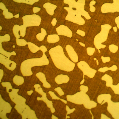 Micrography of a transverse section of the fititng, presenting a coarser structure. The ferrite is red/orange and the austenite is white/yellow.
