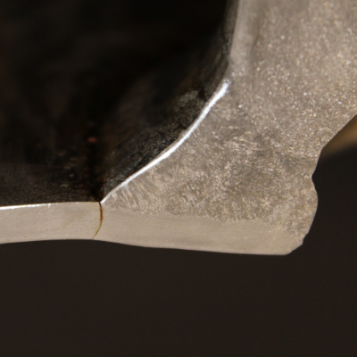 Macrographic detail of the pipe to weldolet weld, and the through wall cracking in the pipe from the margin of the weld.  The pipe thickness is only 5 mm (SCH 10S) but the large thickness of the fitting required several weld passes to create a full penetration weld.