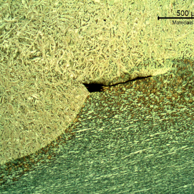 Lack of fusion at the fusion line (between the weld metal and the base metal). This defect is small, probably not detectable by any destructive test and not affecting the fatigue life.
