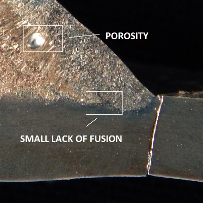 Macrography of a transverse section of the welded joint, at the fatigue crack position in the pipe.  It is very interesting to observe that the crack propagated from the margin of the weld,  independently of the defects in the weld (porosity and lack of fusion), and without relationship with the unbalanced structure at the cap (with a large amount of ferrite).  These characteristics are detailed in the next figures.