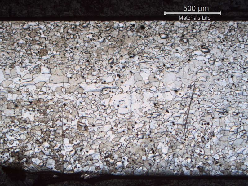 Micrography of a fork longitudinal section, at the handle (close to the transition betwee the scoop and handle). The full thickness is presented in the image and it is possible to see that the ferritic grains are larger in the center of the thickness than close to the surfaces.