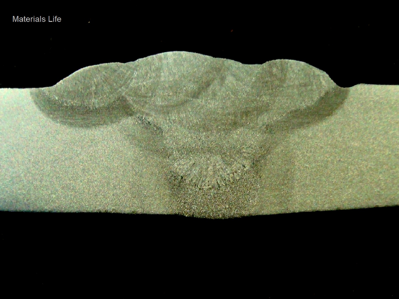 Macrography of a section longitudinal to the pipe and transverse to the weld. The thickness of the pipe is 12,7 mm (1/2") and it was welded in 6 passes, the root pass, one fill pass and four cap passes.