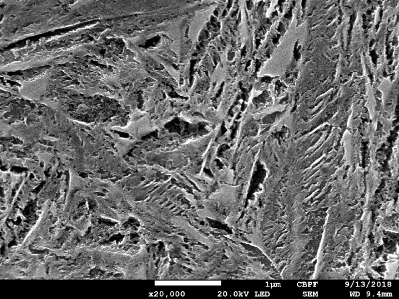 Micrographic detail of the tempered martensite, and small regions (shinning poligons) of austenite-martensite.