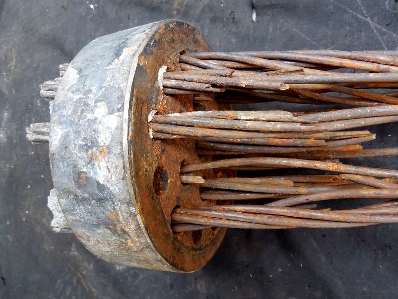 Concrete steel strand general view, presenting fracture of several wires and a corroded aspect.  The full part is composed by 19 strands, each strand using 7 wires, and each wire about 5 mm diameter.