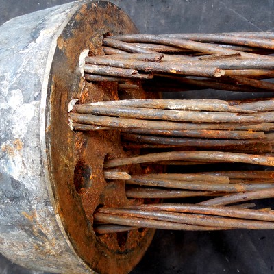 Macro view of individual strand wires emerging from the anchorage fitting, most surfaces covered in reddish-brown corrosion product and several wire ends showing fracture.