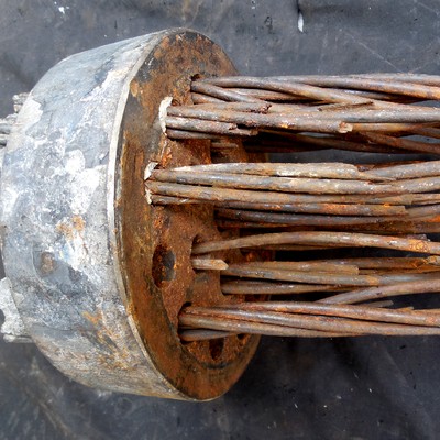 Concrete steel strand general view, presenting fracture of several wires and a corroded aspect. The full part is composed by 19 strands, each strand using 7 wires, and each wire about 5 mm diameter.