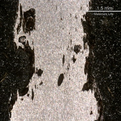Macrography of a typical corroded wire in a longitudinal section, showing loss of thickness by corrosion.