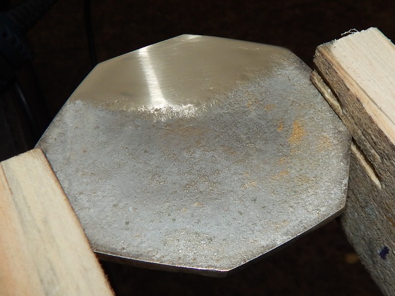 Aspect of the back of the coaster after grinding. The coating was partially removed. The chemical analysis was conducted in the ground part to obtain the composition of the substrate, that showed to be a yellow brass alloy.  It is interesting to note that the alloy presented 2.3% lead.