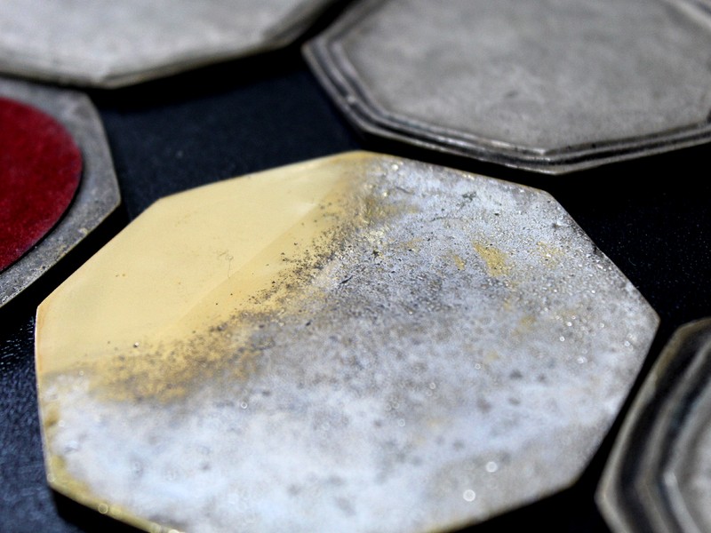 Image presenting the back of the coaster where the microstructure of the substrate was identified. The composition of the brass (about 35% Zn) indicates that the expected structure is alpha plus beta. The front of the coaster presents two grooves which surface morphology was analyzed by scanning electron microscopy.