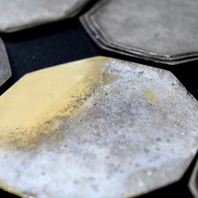 Image presenting the back of the coaster where the microstructure of the substrate was identified. The composition of the brass (about 35% Zn) indicates that the expected structure is alpha plus beta.  The front of the coaster presents two grooves which surface morphology was analyzed by scanning electron microscopy.
