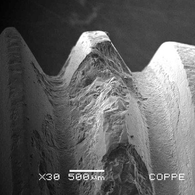 Low magnification SEM image showing the brittle aspect of the cracks in the bolt thread.