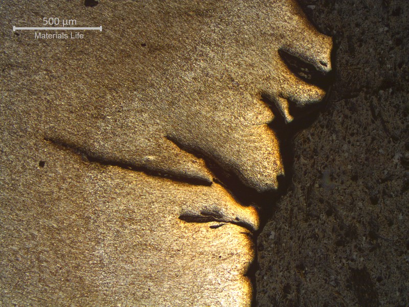 Micrography of the longitudinal section of the pipe, at the thicker part of the fracture, showing several secondary cracks opened to the external side of the pipe. There are no problems in the material structure and the cracks are associated to large plastic deformation.