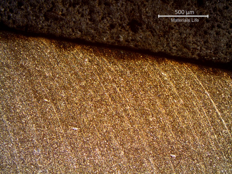 Micrography of a longitudinal section of the pipe at the fracture position, in the thinner thickness. The diagonal line in the middle of the figure is the fracture surface and it is possible to identify that it was sheared with strong plastic deformation. The segregation bands (longitudinal lines) are deformed in the direction of the failure shearing, in a depth that is several milimeters deep in the pipe, from the fracture surface.