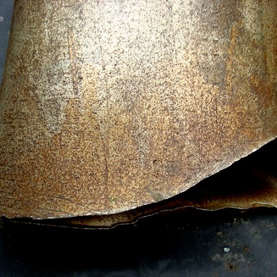 Lateral image of a collapsed API 5D grade S135 drill pipe, presenting the fractured region (bottom of the figure) at the pipe body.  Although the pipe steel is of a high strenght, the fracture characteristic is ductile, evidencing strong plastic deformation.