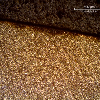 Micrography of a longitudinal section of the pipe at the fracture position, in the thinner thickness.  The diagonal line in the middle of the figure is the fracture surface and it is possible to identify that it was sheared with strong plastic deformation.  The segregation bands (longitudinal lines) are deformed in the direction of the failure shearing, in a depth that is several milimeters deep in the pipe, from the fracture surface.