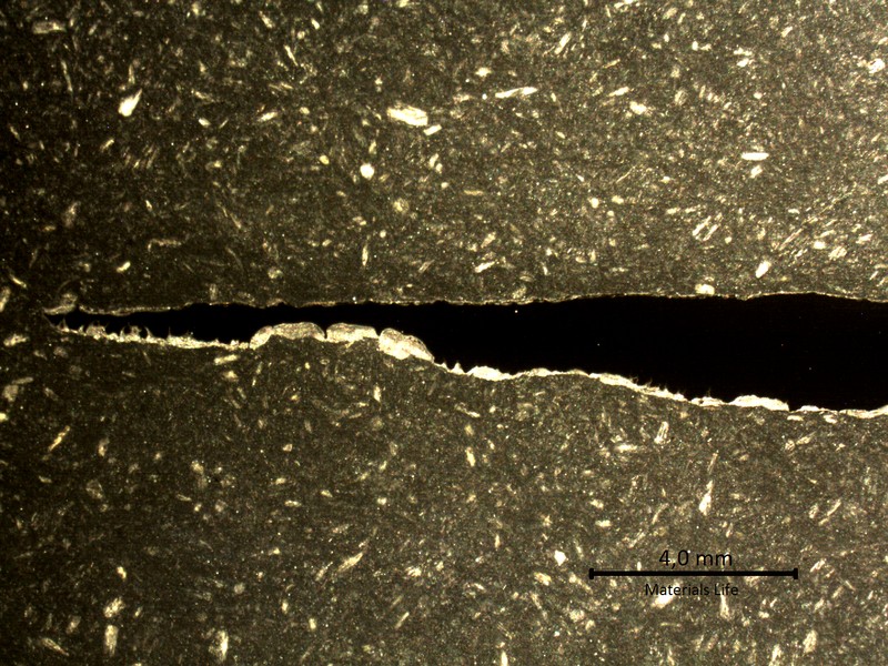 Transverse section macrography of the plate where the degradation by thinning is worst, close to the original corners of the tube. The thinning is occurrring from the product reaction side (side A to the bottom of the figure). The macrography shows a reduction in the thickness from 2 mm (right side, sample 2) to almost zero (left side, sample 1).