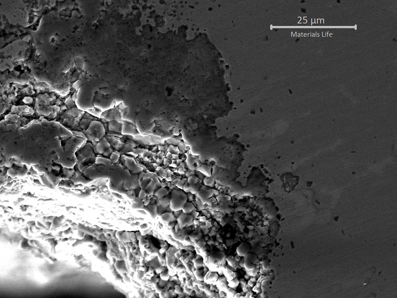 SAMPLE 1 AT THE FRACTURE - Micrographic detail by scanning electron microscopy, as polished,  of the oxides that are penetrating in the grain boundaries.  The EDS showed high Molibdenium content in the penetrating oxides.  The process uses Mo oxides to make metallic Mo and the high Mo content at the surface could be responsible for reducing the oxidation resistance of the material and intensifying the thinning at the process side (side A).