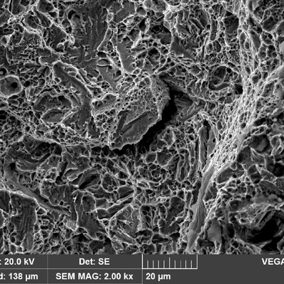 Fractography of the broken Charpy V testpiece, in a high strength steel that absorbed 11 Joules at 20°C.  Quasicleavage and dimples are the main fracture micromechanisms with some secondary cracks that appear to be intergranular, exactly as the fracture of the part.