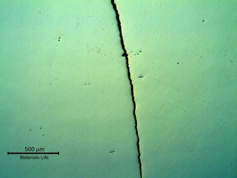 Micrography in low magnification, as polished, of the crack in the valve thickness,  showing the straight aspect of the fatigue propagation.