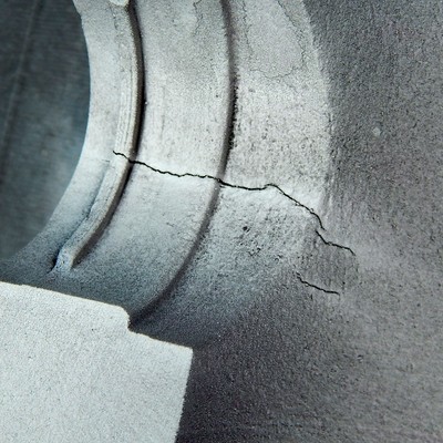 Magnetic particle test of the same cracks at the edge of the actuator hole, viewed from inside of the body.  The cracks appeared more clearly with this test than with the penetrant test, suggesting that the cracks are not fully opened to the surface.